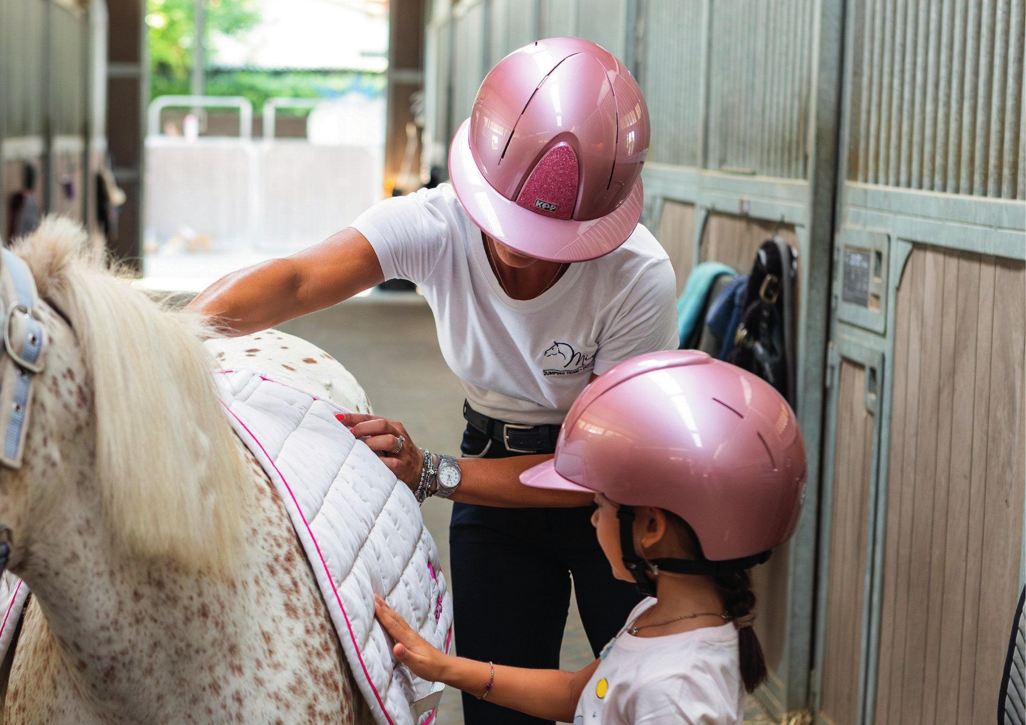 Rider and child in pink KEP Smart Nova helmets in the stable